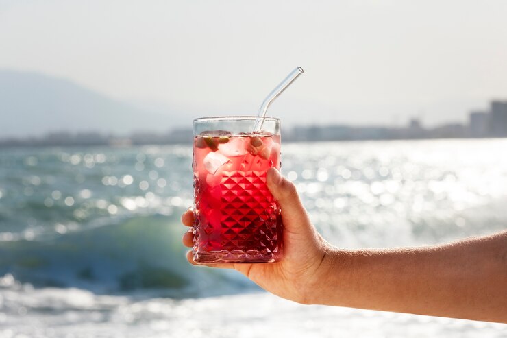 Free Photo side view hand holding sangria at seaside