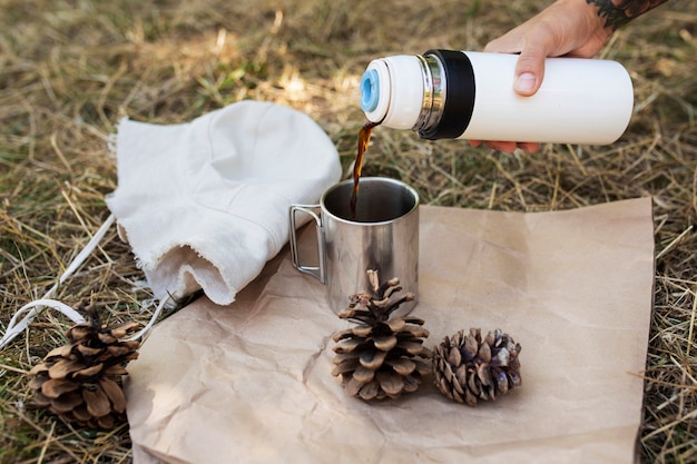 Free photo side view hand pouring coffee from flask