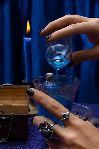 Side view hand pouring potion into glass