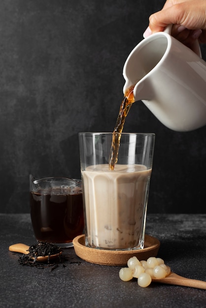 Free photo side view hand pouring tea in cup