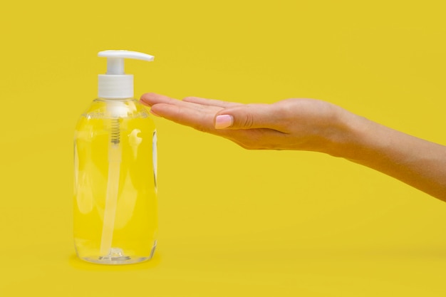 Side view of hand using liquid soap