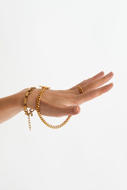 Бесплатное фото Рука с золотыми цепями, вид сбоку
