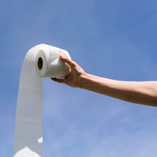 Free photo side view hand with toilet paper roll