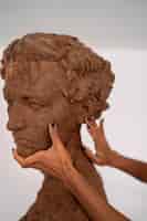 Free photo side view hands clay sculpting