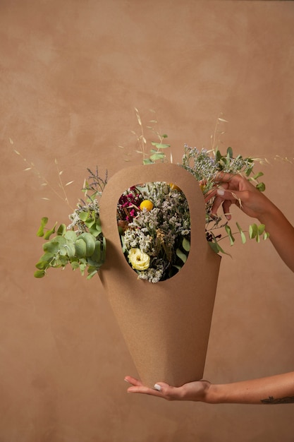 Вид сбоку руки держат корзину с цветами