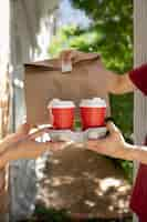 Free photo side view hands holding coffee cups