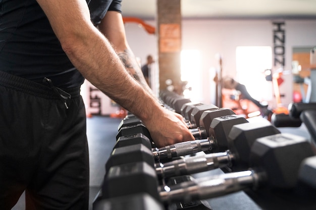 Free photo side view hands holding dumbbells