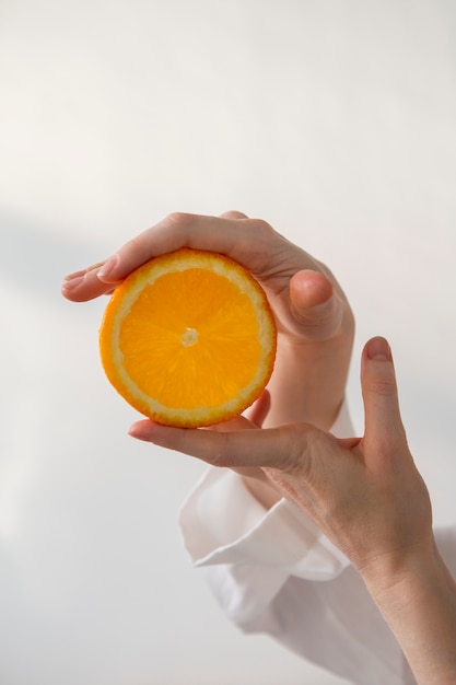 Side view hands holding orange slice