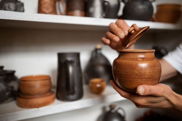 Foto gratuita mani di vista laterale che tengono vaso