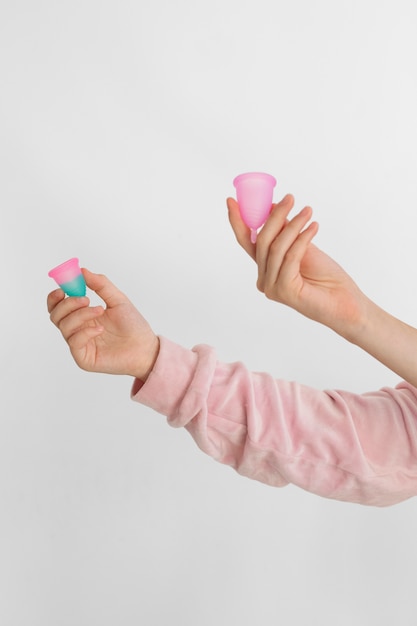 Side view hands holding reusable menstrual products