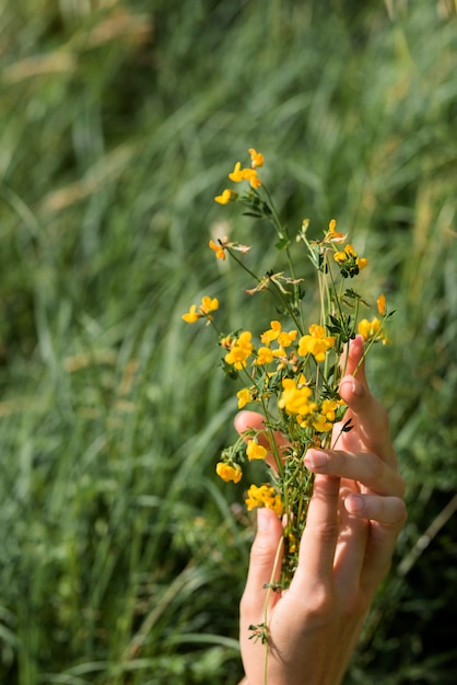 노란색 꽃을 들고 측면 보기 손