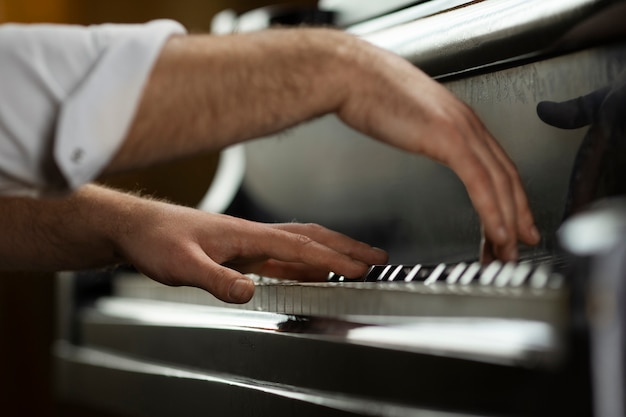 Free photo side view hands playing piano