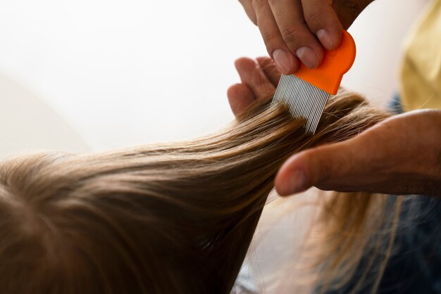 Side view hands using lice comb