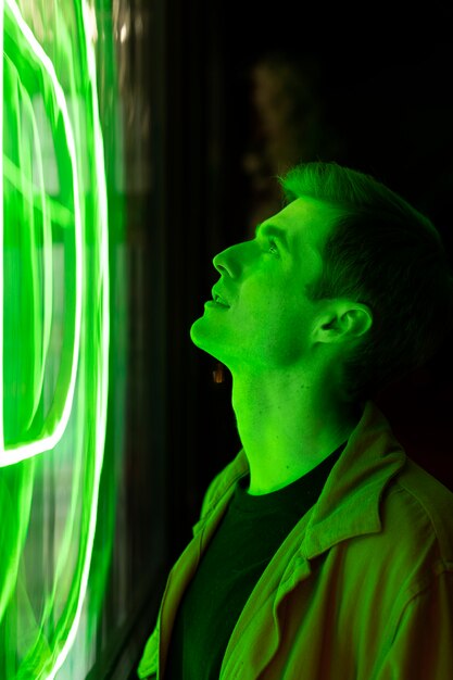 Side view of a handsome man at night in neon light