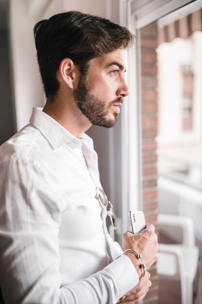 Side view of a handsome man with smartphone