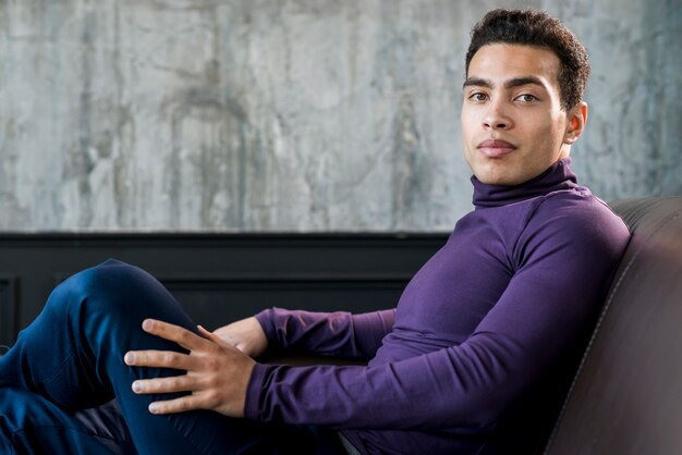 side view of a handsome young man looking at camera