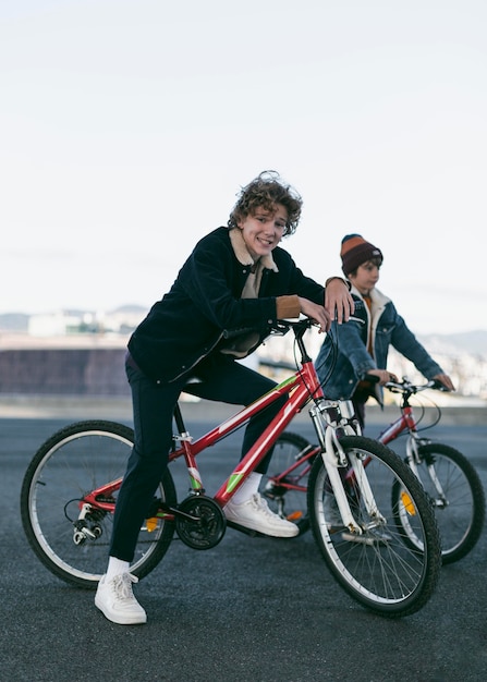 그들의 자전거와 함께 도시에서 야외에서 행복한 소년의 측면보기