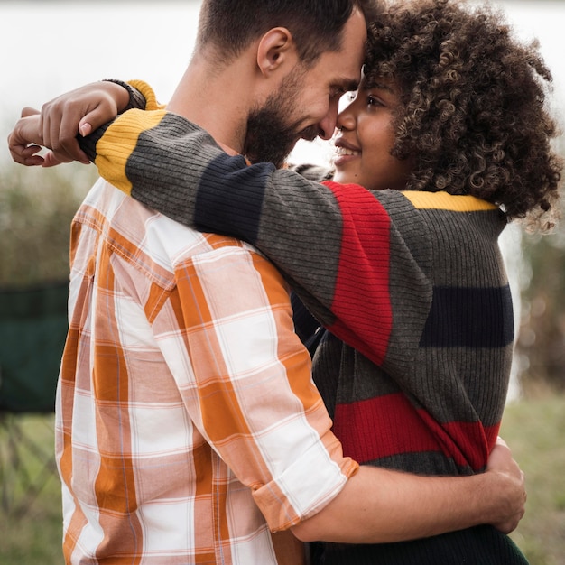Side view of happy couple hugging outdoors