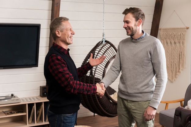 Side view of happy father and son shaking hands