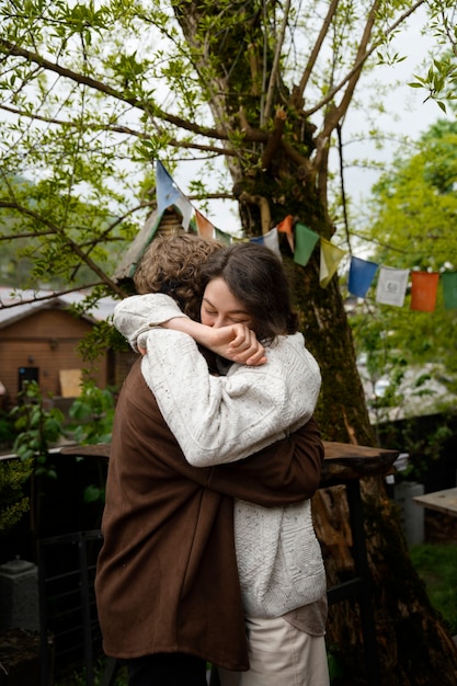 Free photo side view happy friends hugging in nature