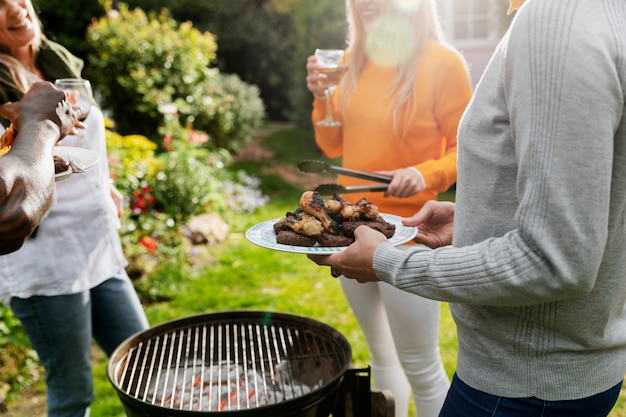 Side view happy friends making barbecue