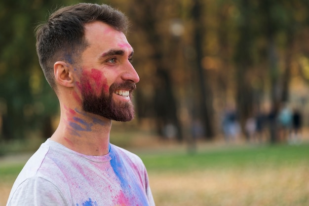 Free photo side view of happy man at holi festival