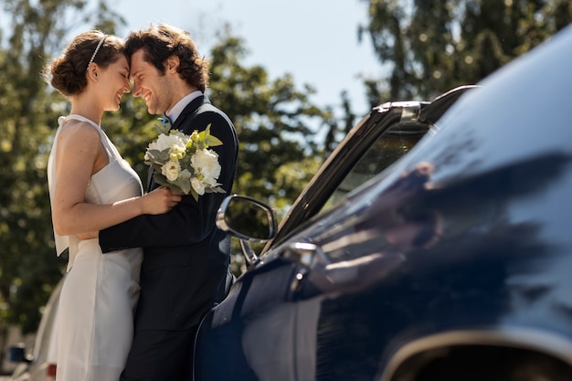 Free photo side view happy married couple near car