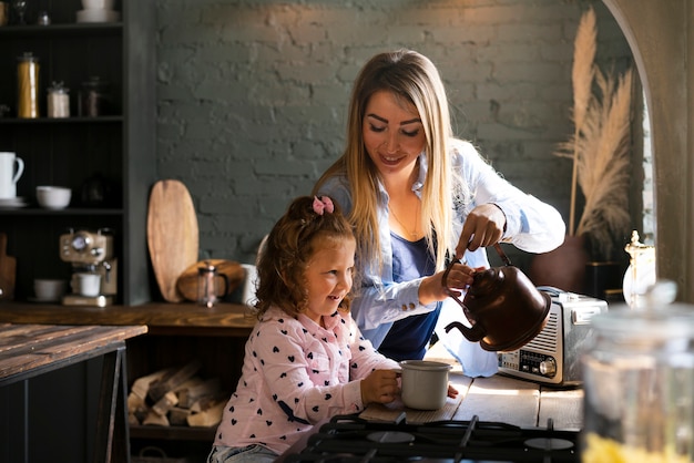 Side view happy mother and daughter in the kitchen