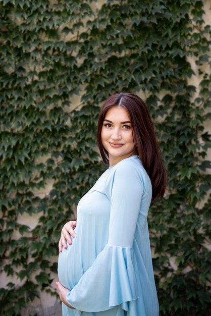 Side view happy pregnant woman posing outdoors