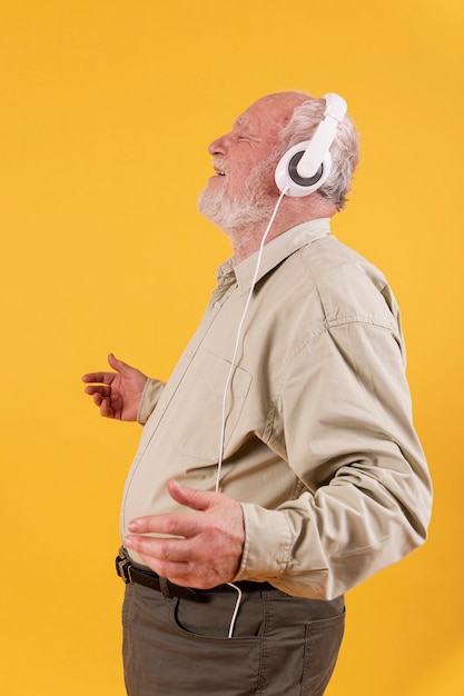 Side view happy senior listening music