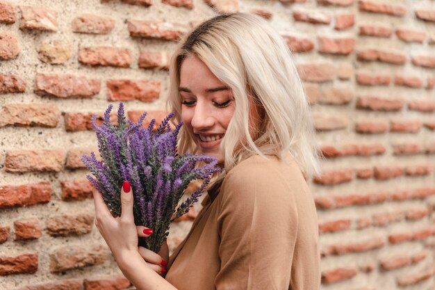 Side view of happy woman holding bouquet of lavender