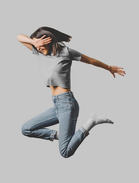 Side view of happy woman jumping in the air