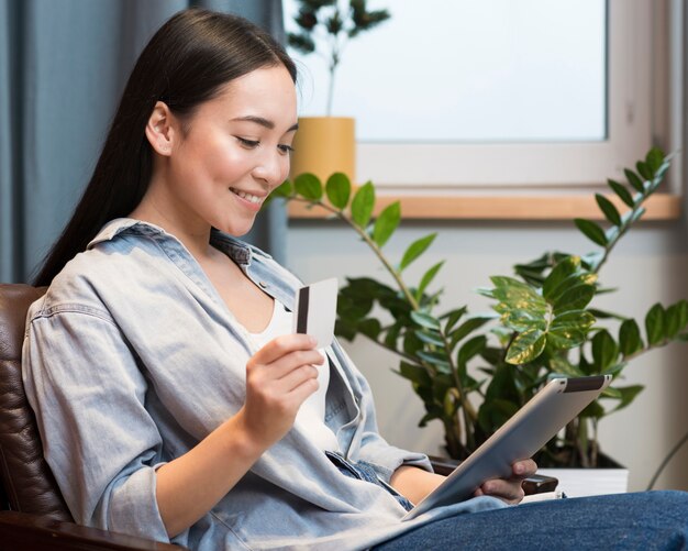 Side view of happy woman ordering online from home