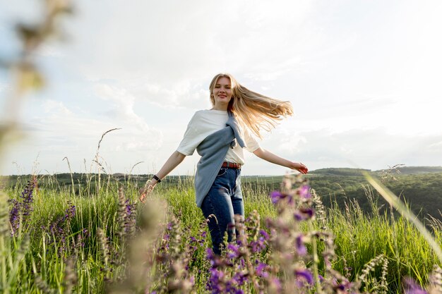 Side view of happy woman posing through field