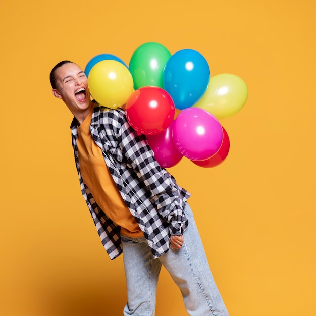 Side view of happy woman with colorful balloons