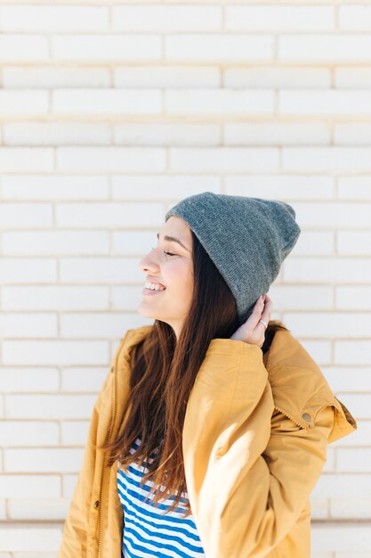 Side view of a happy woman with her eyes closed wearing knit hat 