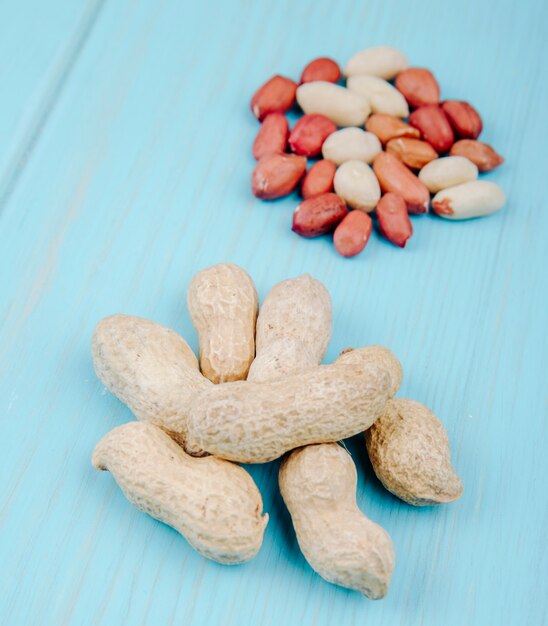 Side view of heap of peanuts in shell isolated on blue background