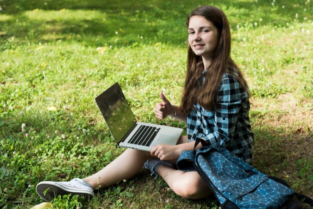 Side view high angle shot of school girl using laptop