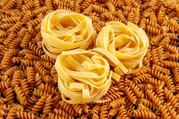 Side view and high resolution photo of various raw Italian pastas lined up in a row