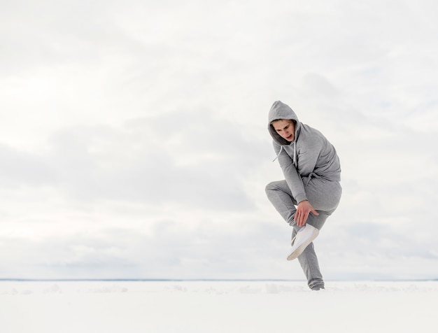 Side view of hip hop artist dancing in the snow with copy space