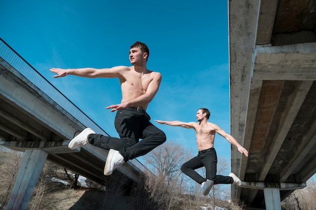 Side view of hip hop dancers posing mid-air