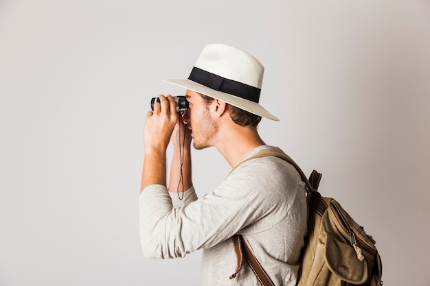 Side view of hipster man using binoculars