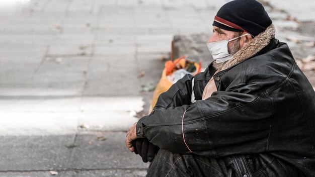 Side view of homeless man outdoors with cane and copy space