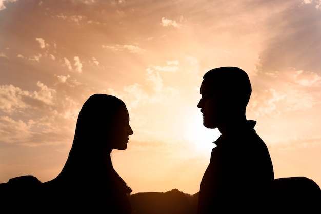 Free photo side view human silhouettes posing with sky background