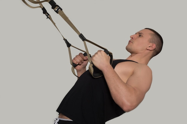 Side view image of skilled sportsman having arms training on bodybuilder