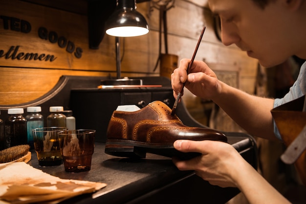 Side view image of young concentrated shoemaker