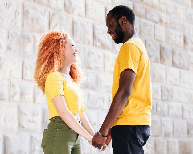 Side view of interracial couple holding hands