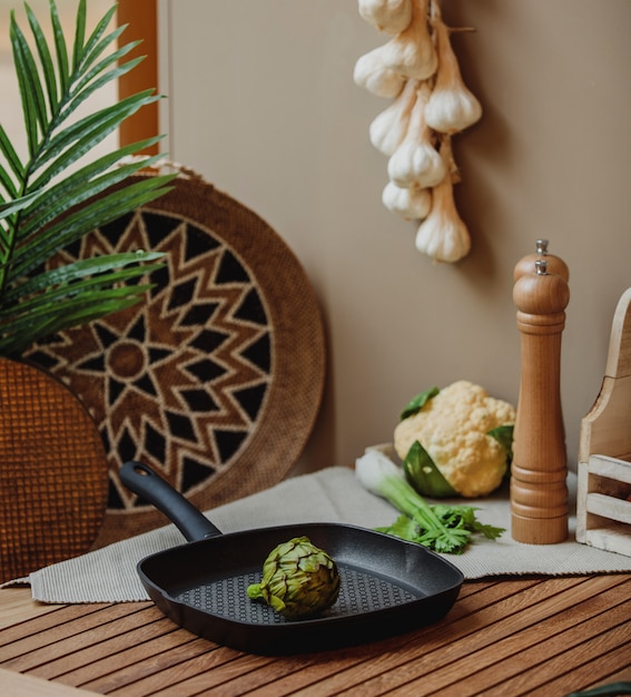 Side view of islated green brussels sprout in a pan on a wooden table