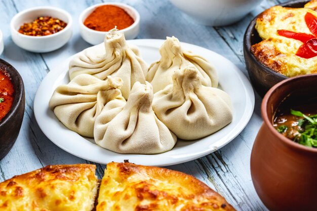 Side view khinkali dumplings with ground meat onion salt and pepper on a plate