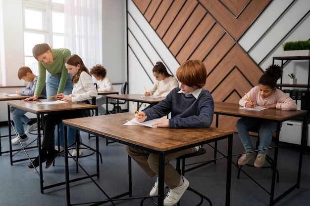 Foto gratuita bambino di vista laterale che tradisce alla prova della scuola